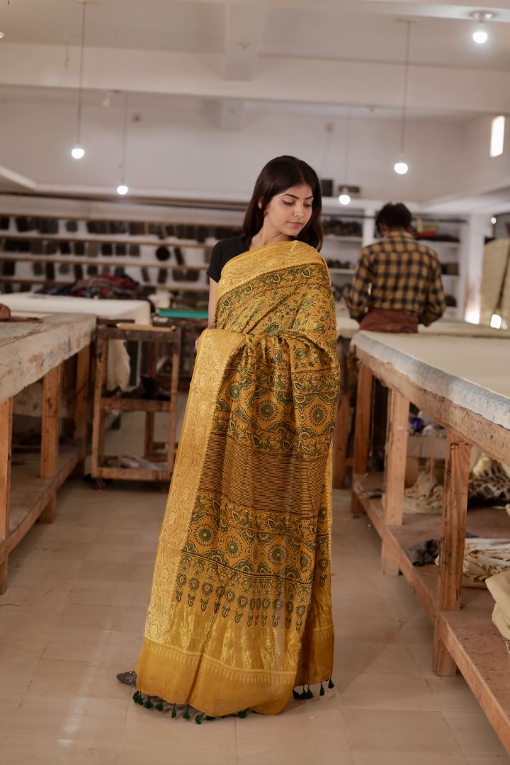 Elegant antique gold Ajrakh saree crafted in lightweight Chanderi silk with a rich zari border