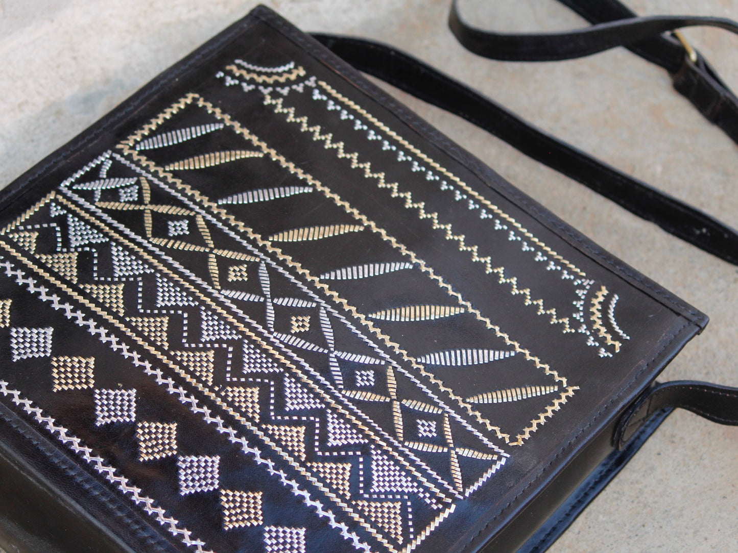 Artisan-made black leather bag featuring traditional metallic zari embellishments