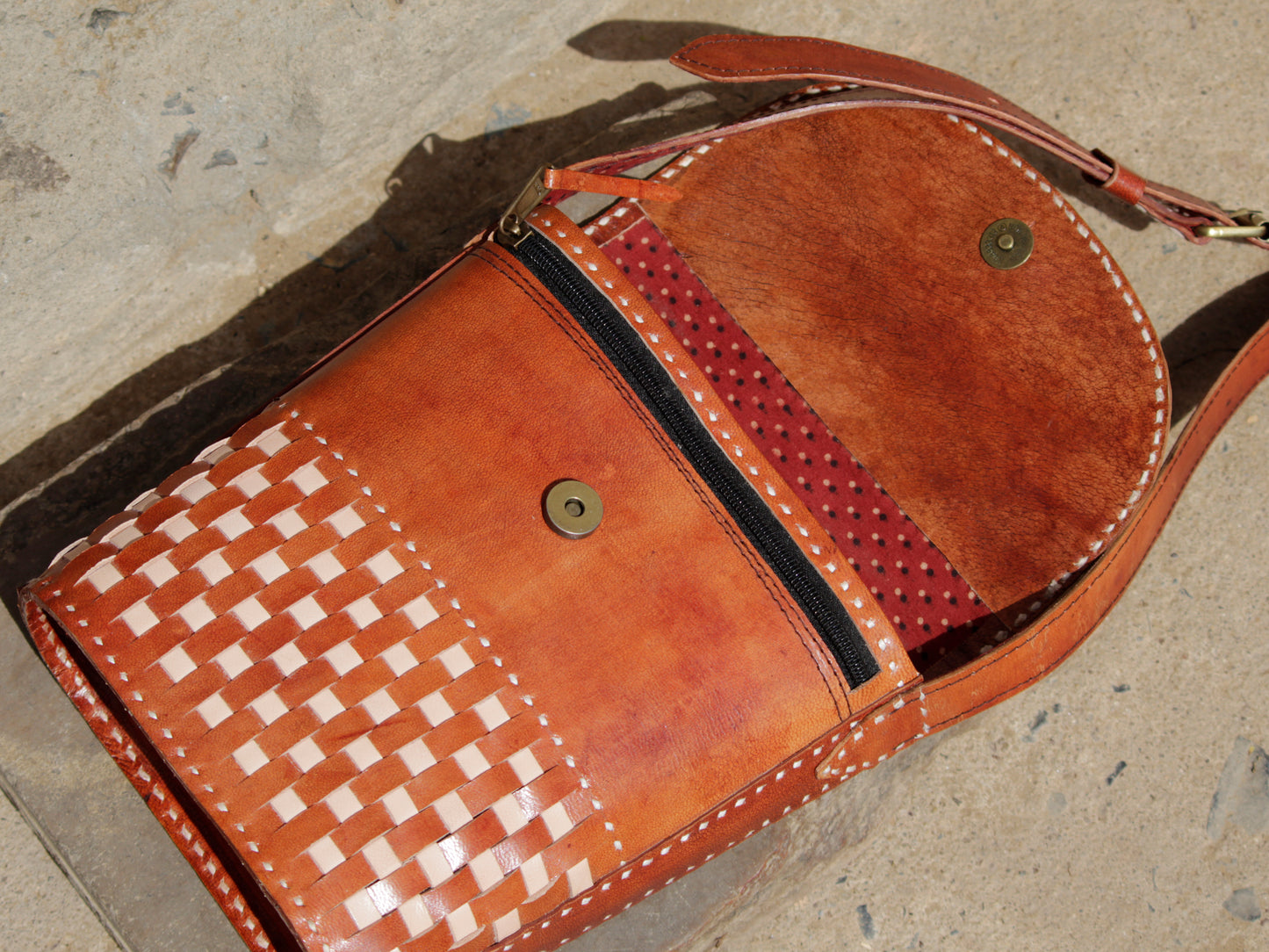 Artisan-made leather sling bag adorned with traditional thread embroidery and fine detailing