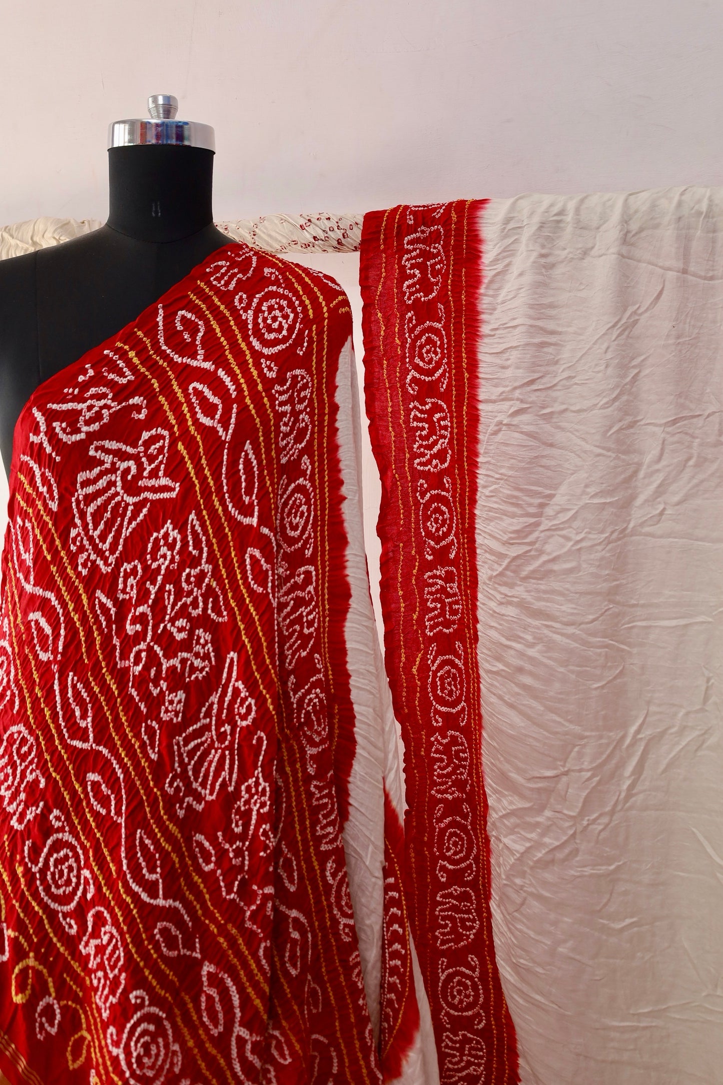 Premium ivory red Bandhani Gajji silk saree highlighting fine artisan craftsmanship and festive elegance