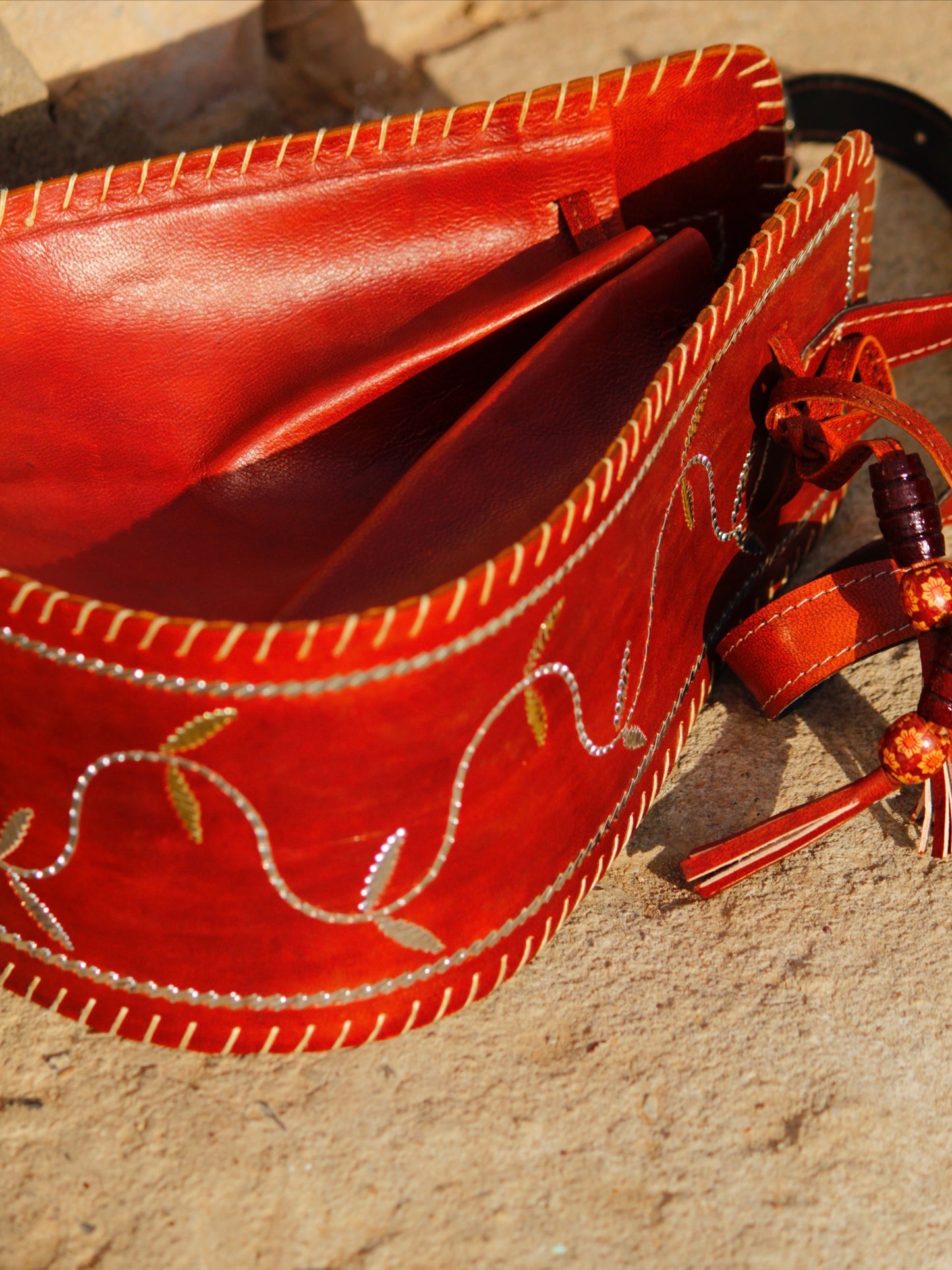 Premium leather potli bag combining durable leather construction with heritage zari artistry