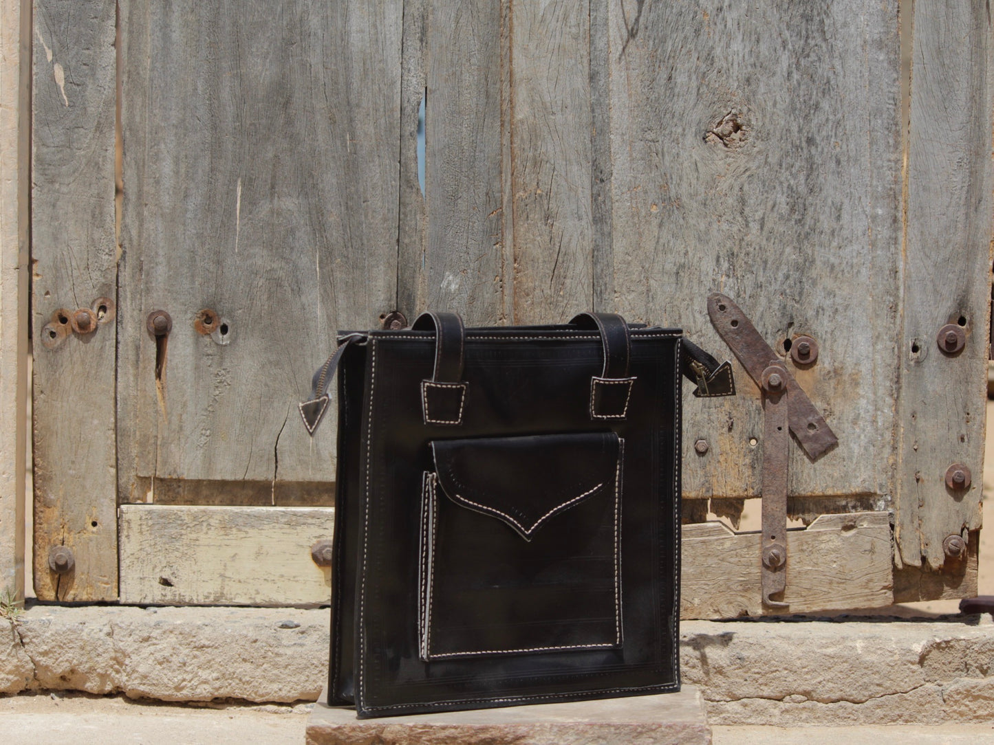 Black handstitched leather bag crafted from premium leather with meticulous handmade detailing