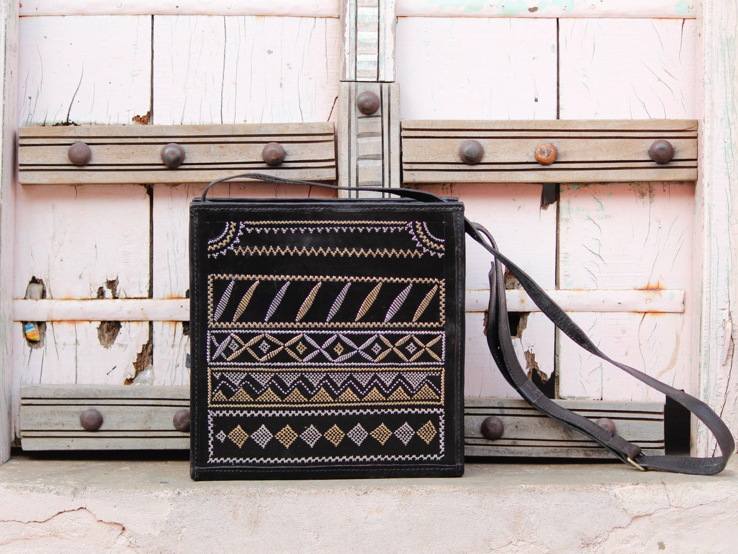 Black leather bag adorned with intricate zari work on premium handcrafted leather