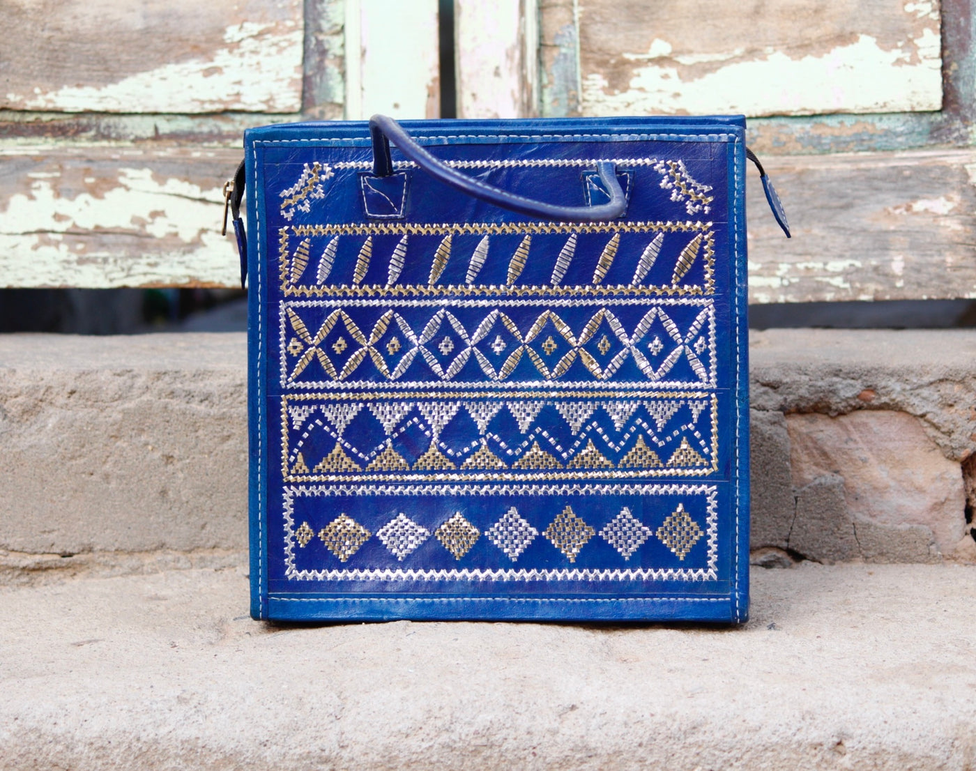 Blue leather bag adorned with intricate zari work on premium handcrafted leather