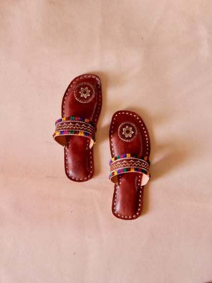 Brown handstitched leather flats showcasing traditional craftsmanship and comfortable design