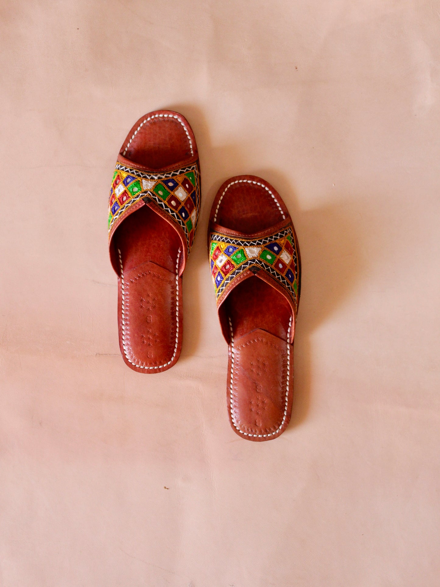 Embroidered handstitched leather flats showcasing traditional craftsmanship and intricate detailing