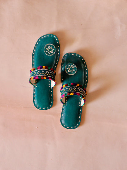 Green handstitched leather flats showcasing traditional craftsmanship and comfortable design