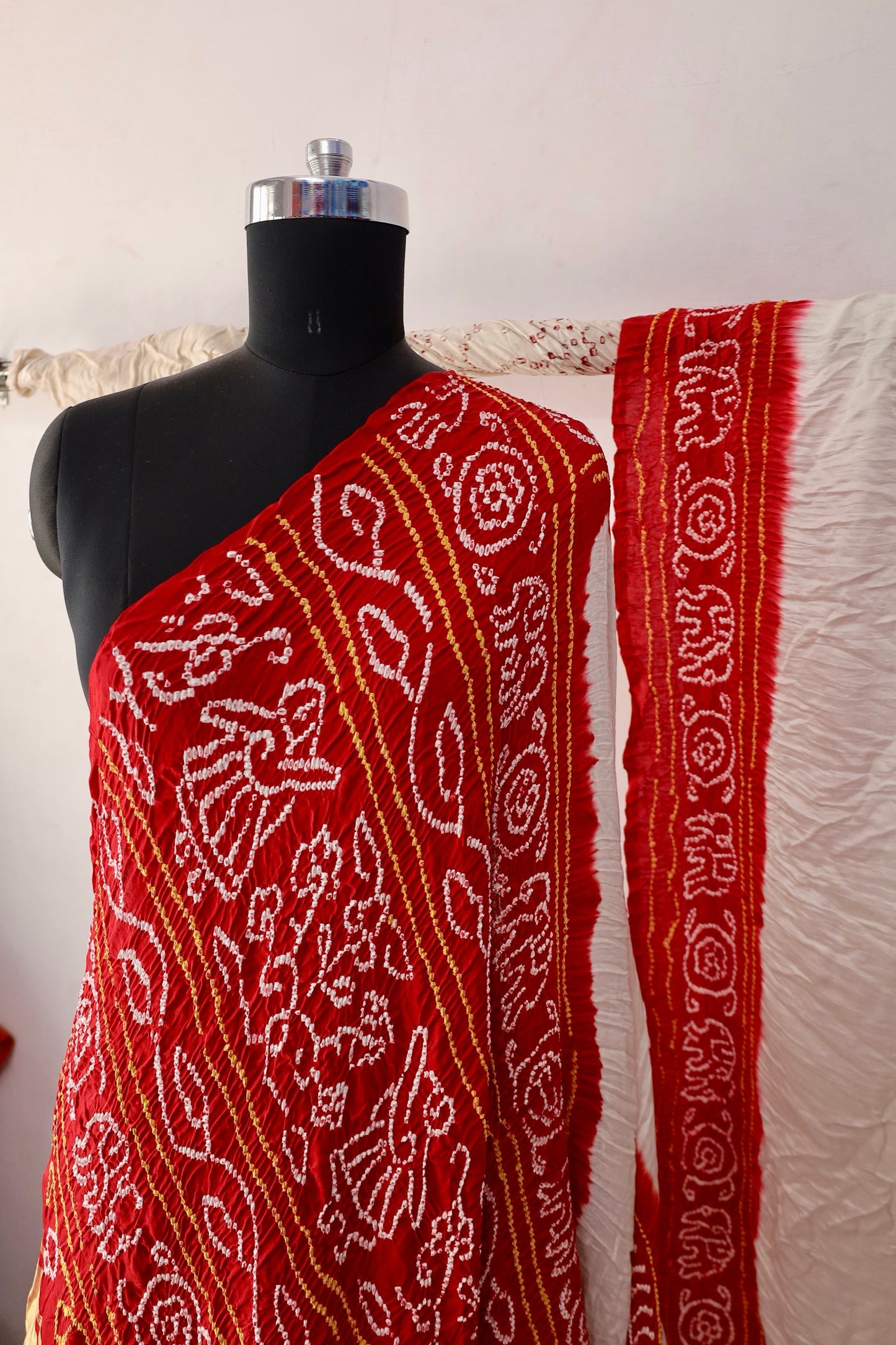 Ivory red Bandhani Gajji silk saree featuring intricate tie-dye patterns and an elegant zari pallu
