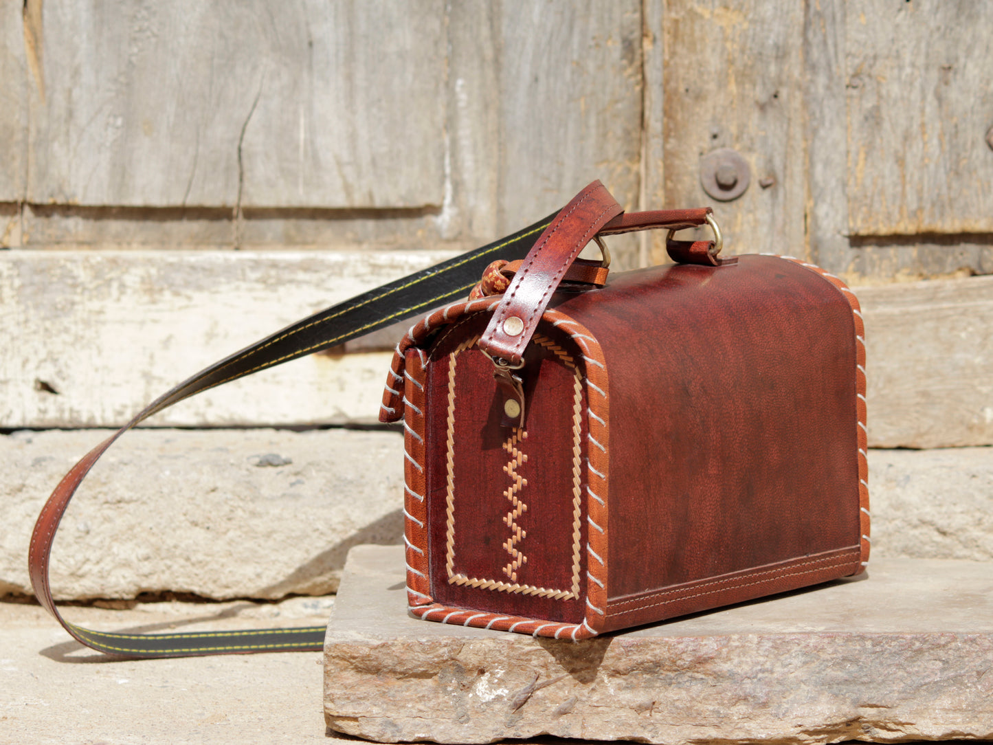 Artisan-made leather hut bag adorned with traditional thread embroidery and fine detailing