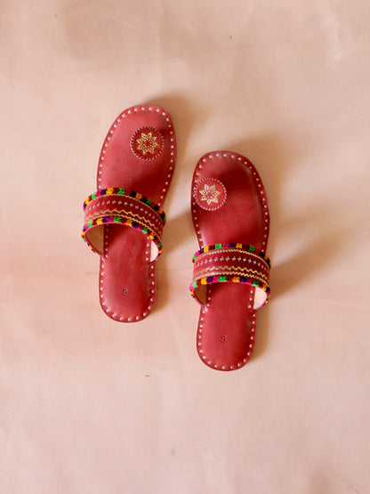 Red handstitched leather flats showcasing traditional craftsmanship and comfortable design