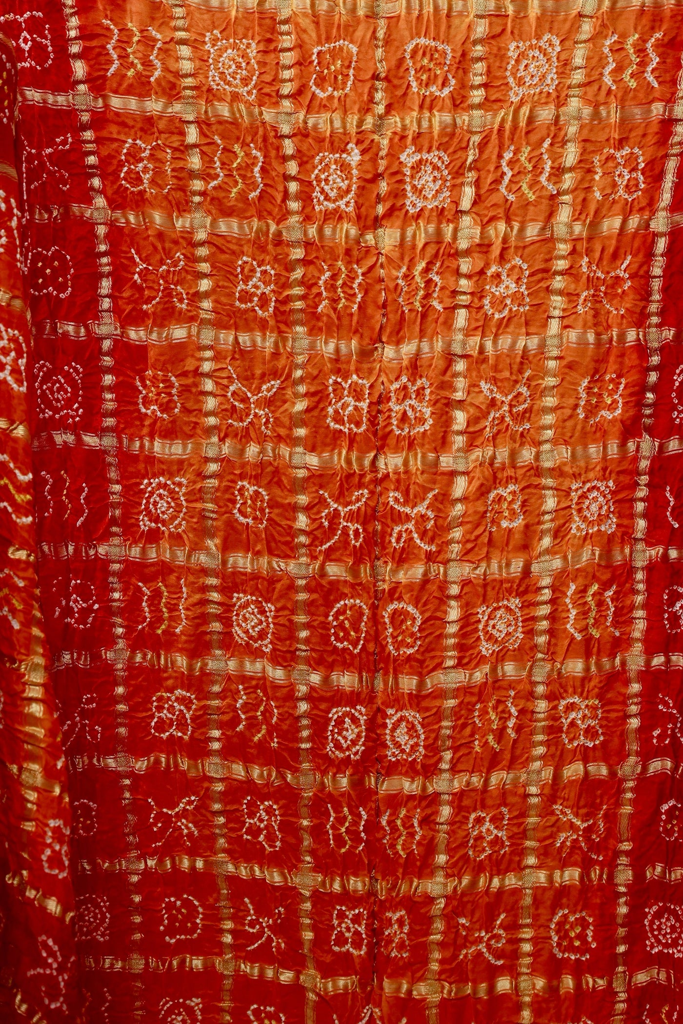 Handcrafted sunset Gajji silk saree showcasing authentic Bandhani Gharchola artistry and elegant drape