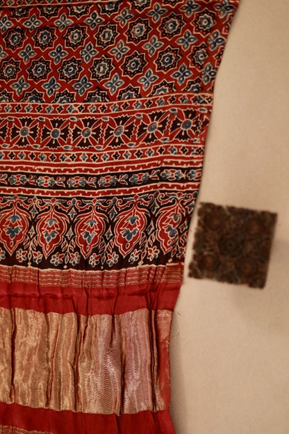 Traditional coral red Ajrakh modal silk dupatta showcasing authentic artisan craftsmanship and decorative borders