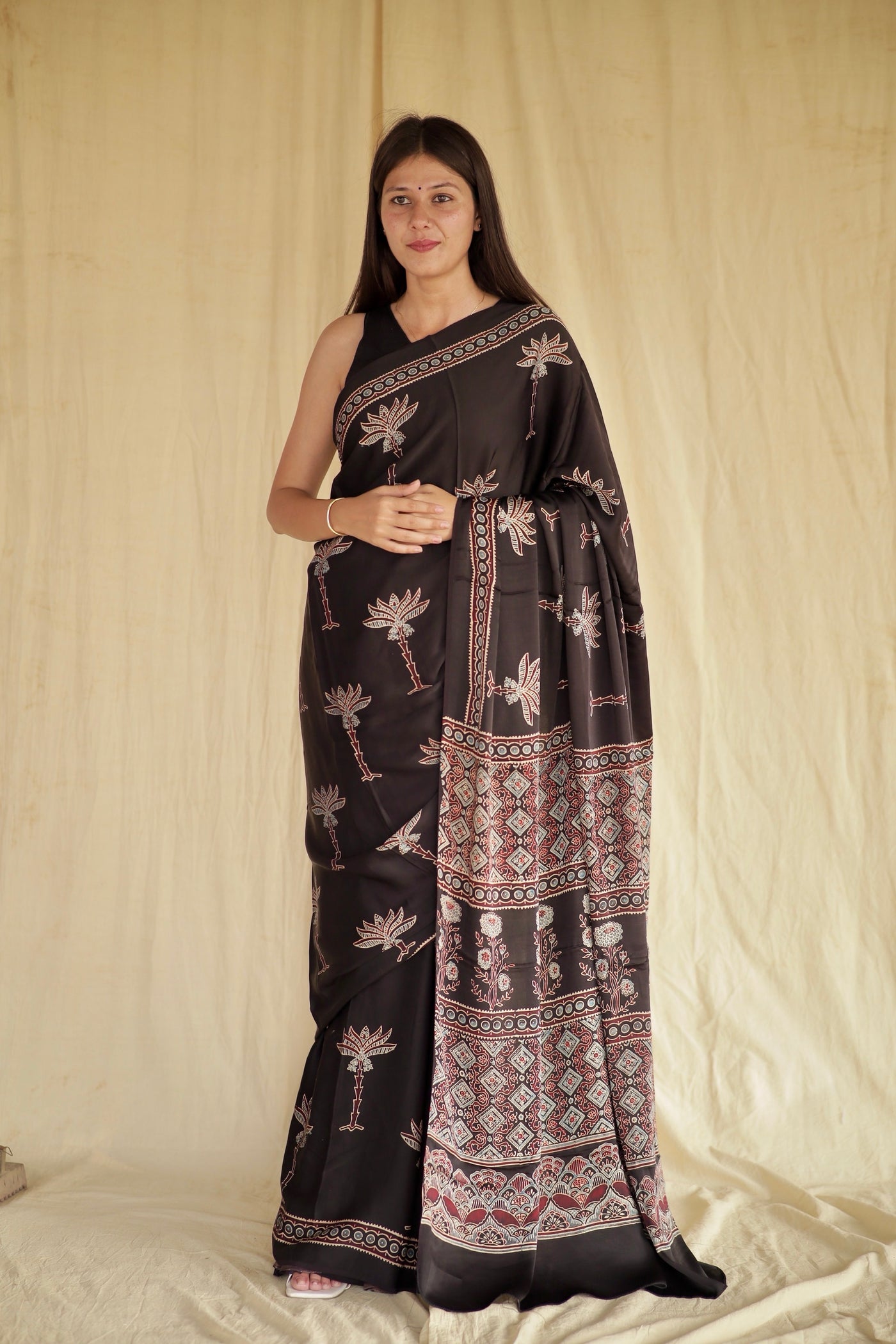 Black Lotus Ajrakh modal silk saree featuring intricate hand block printed lotus motifs and a graceful drape