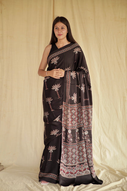 Black Lotus Ajrakh modal silk saree featuring intricate hand block printed lotus motifs and a graceful drape