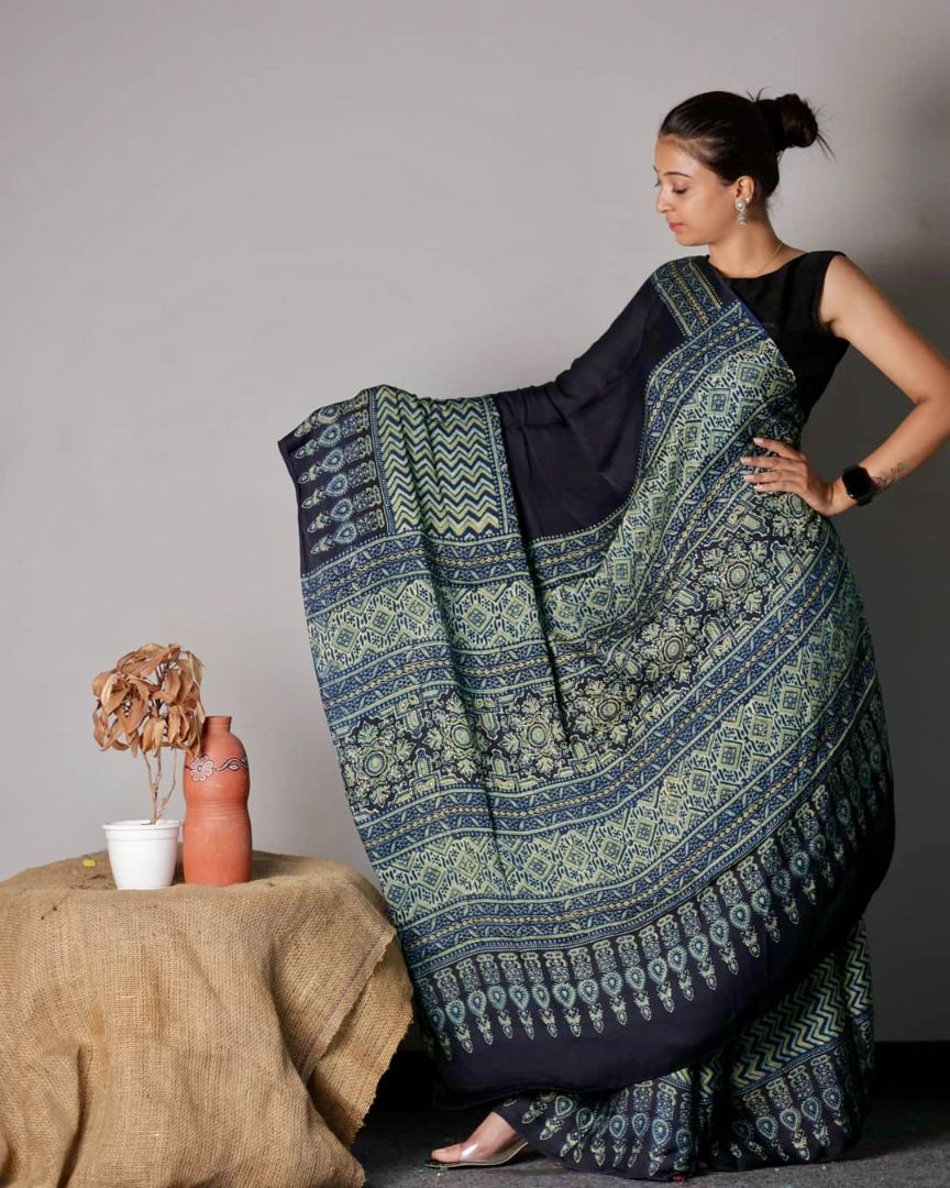 Black and teal Ajrakh modal silk saree featuring intricate hand block printed motifs and a graceful drape