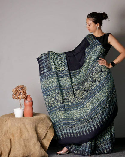 Black and teal Ajrakh modal silk saree featuring intricate hand block printed motifs and a graceful drape