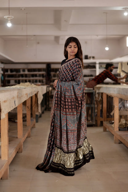 Black Ajrakh modal silk saree featuring intricate hand block printed motifs and a rich zari border