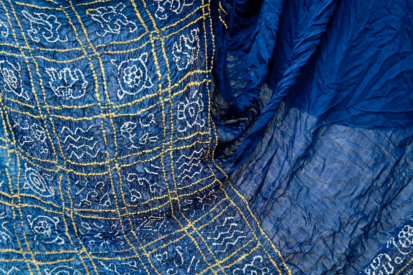 Premium midnight blue Bandhani silk saree highlighting fine artisan craftsmanship and festive elegance
