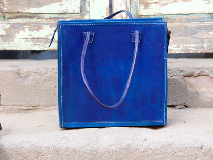 This Blue Leather Bag with Zari Work is a stunning blend of premium leather craftsmanship and traditional Indian artistry. 
