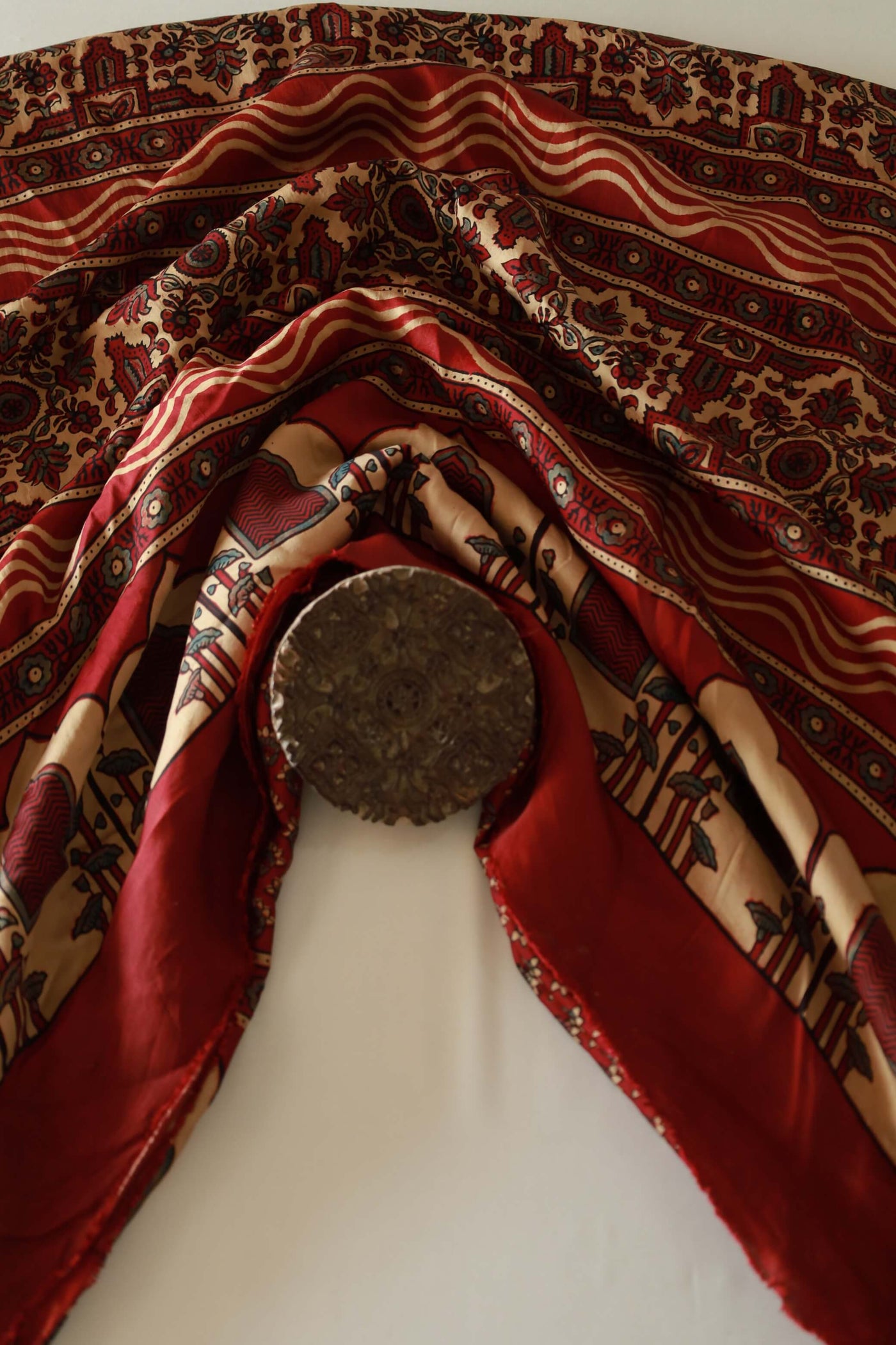 Burgundy Ajrakh modal silk saree featuring intricate hand block printed motifs and a graceful drape