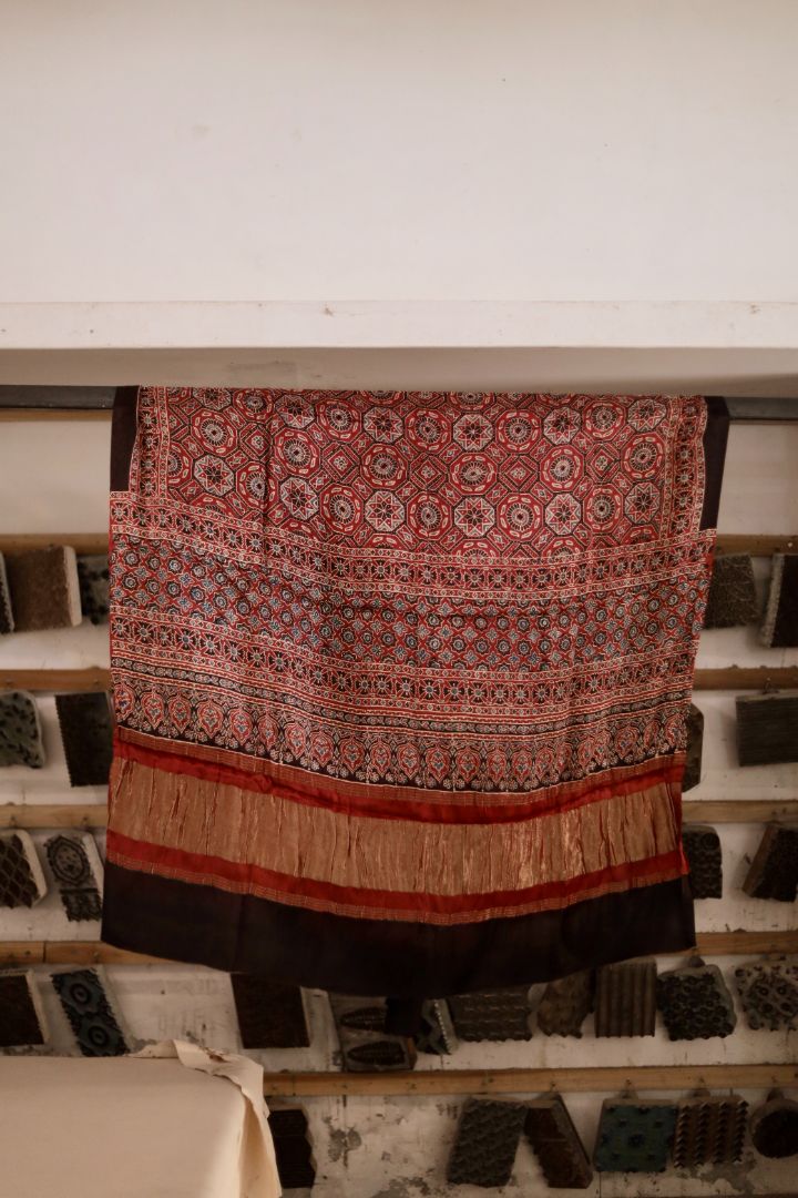 Burnt rust Ajrakh modal silk dupatta with Lagdi Patta featuring intricate block printed motifs and elegant drape
