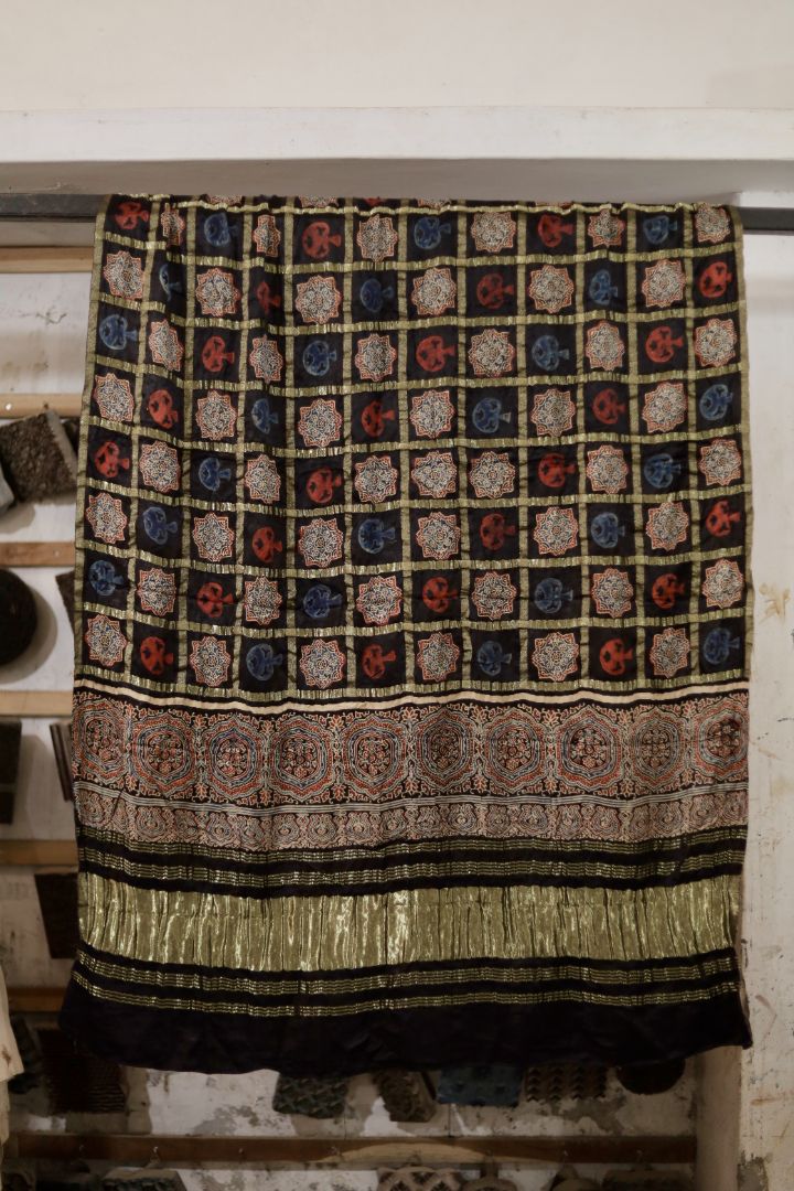 Charcoal black Ajrakh modal silk dupatta with Lagdi Patta featuring intricate block printed motifs and elegant drape
