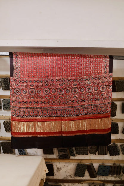Coral red Ajrakh modal silk dupatta with Lagdi Patta featuring intricate block printed motifs and elegant drape