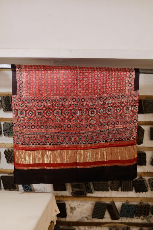 Coral red Ajrakh modal silk dupatta with Lagdi Patta featuring intricate block printed motifs and elegant drape