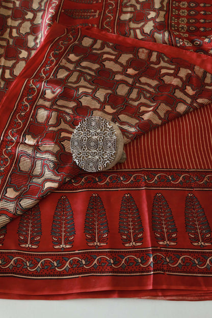 Crimson red Ajrakh modal silk saree featuring intricate hand block printed motifs and a graceful drape