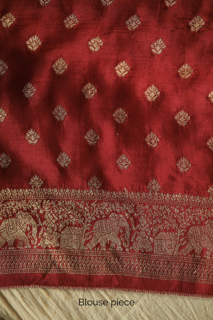 Elegant crimson red Ajrakh saree crafted in Dola silk with detailed artisan block printing. Premium crimson red Dola silk saree showcasing heritage-inspired Ajrakh designs and fluid fall