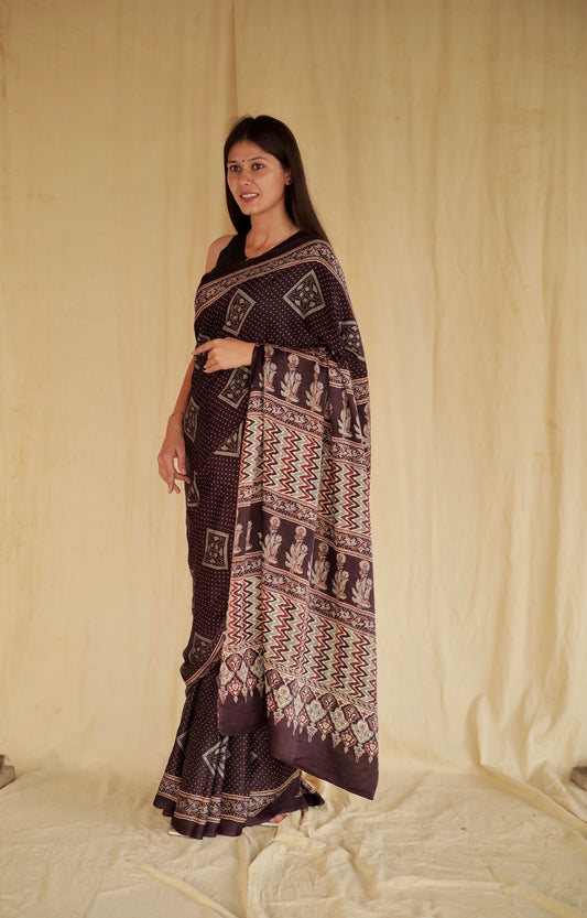 Deep black Ajrakh modal silk saree featuring intricate hand block printed motifs and a graceful drape