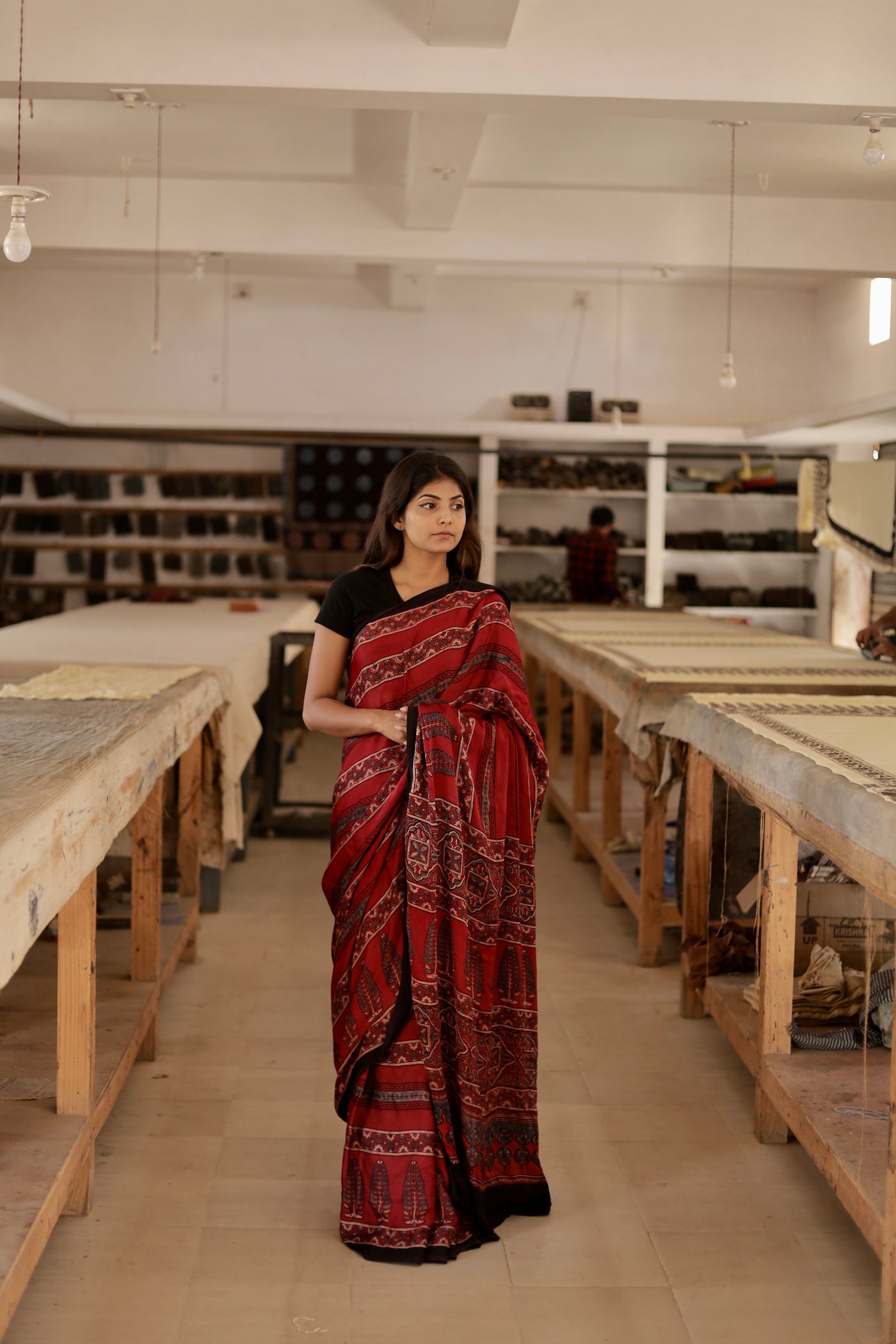 Deep garnet Ajrakh modal silk saree featuring intricate hand block printed motifs and a graceful drape