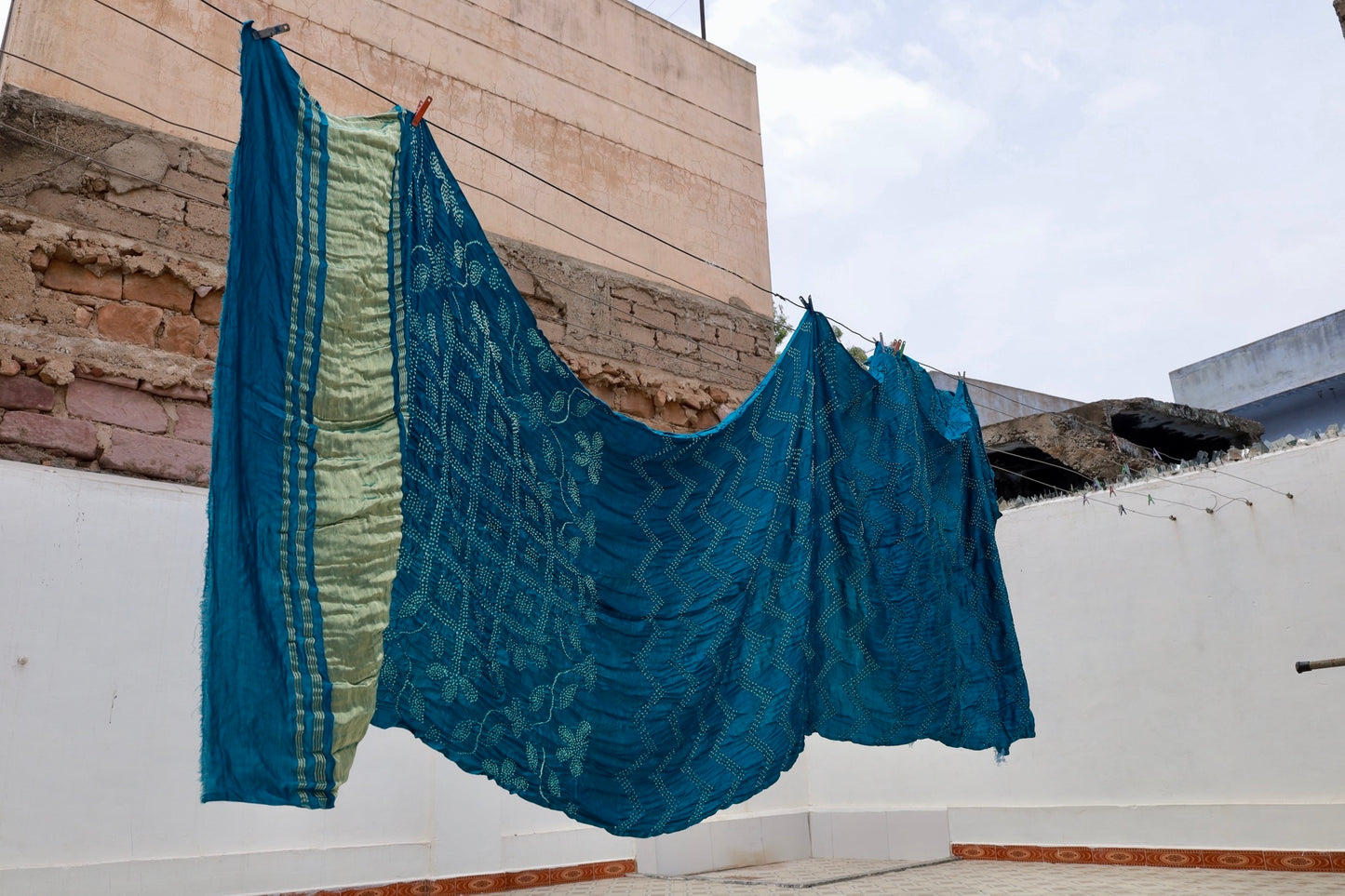 Deep sea Rai Bandhani silk saree featuring intricate tie-dye patterns and an elegant zari pallu