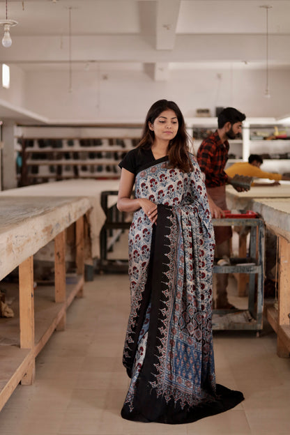 Dove grey Ajrakh modal silk saree featuring intricate hand block printed motifs and a graceful drape