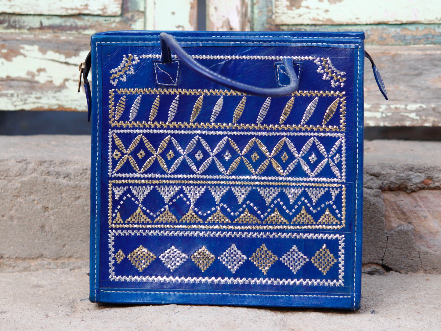 Blue leather bag adorned with intricate zari work on premium handcrafted leather