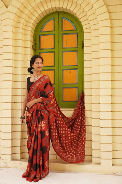 Elegant brick red Ajrakh saree in modal silk showcasing skilled artisan block printing