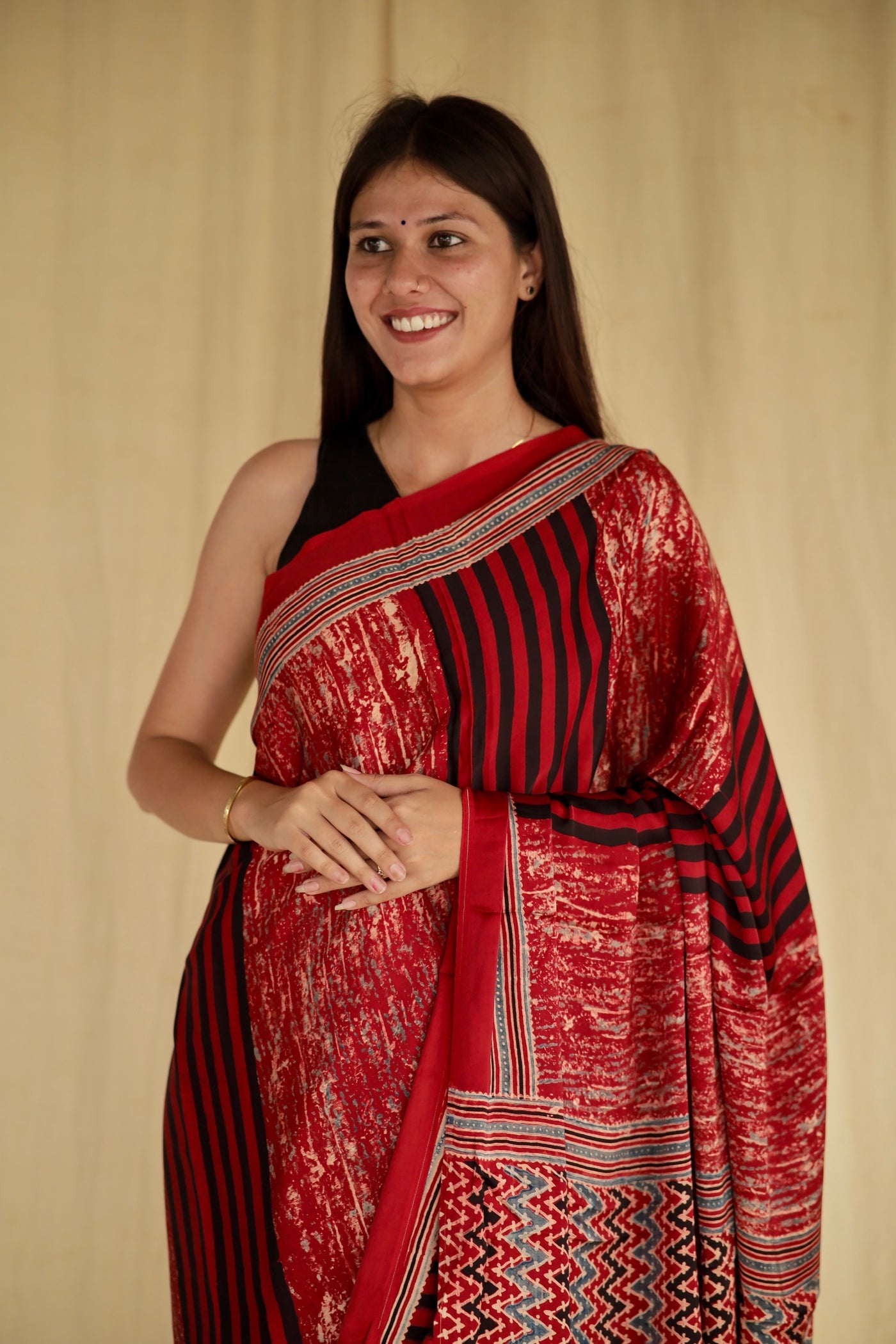 Elegant cherry red Ajrakh saree in modal silk showcasing skilled artisan block printing techniques