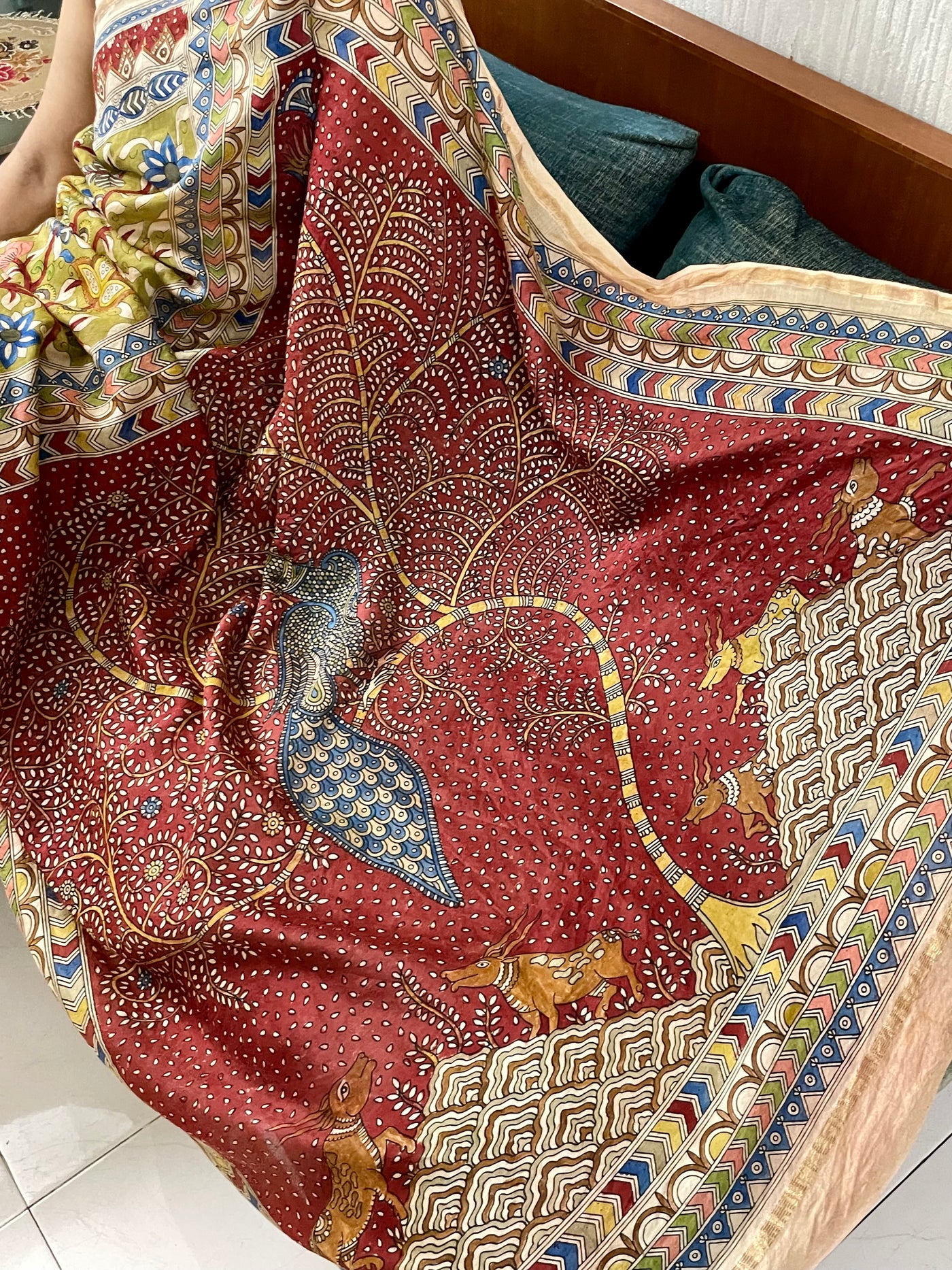 Elegant crimson saree showcasing detailed Mata Ni Pachedi artwork created by skilled artisans