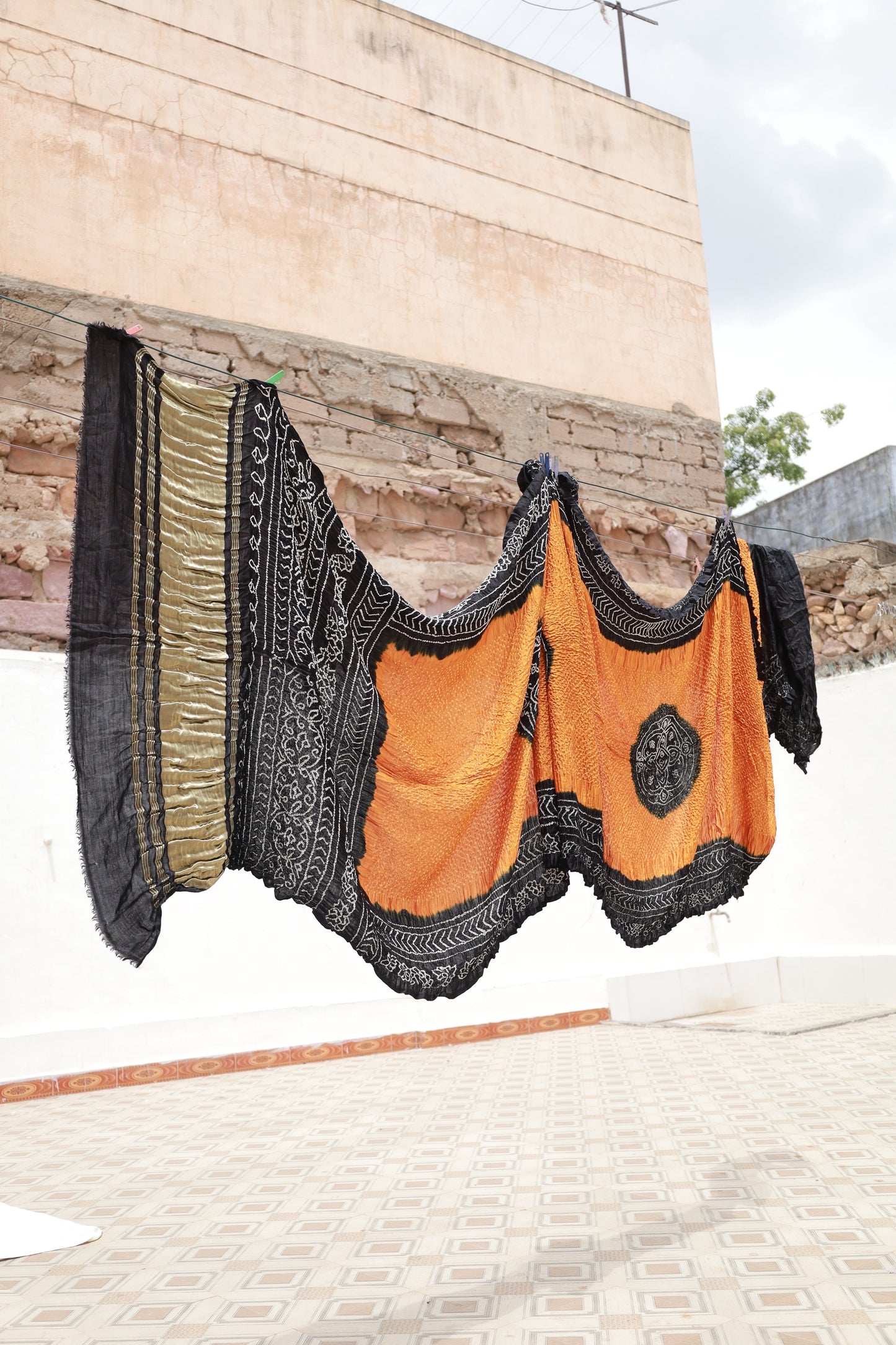 Premium ember Bandhani silk saree highlighting fine artisan craftsmanship and festive elegance