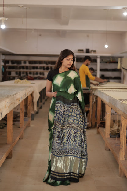 Elegant emerald green Ajrakh modal silk saree showcasing artisan clamp dye techniques and rich zari border