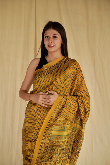 Elegant golden mustard Ajrakh saree in Chanderi silk showcasing skilled artisan block printing techniques