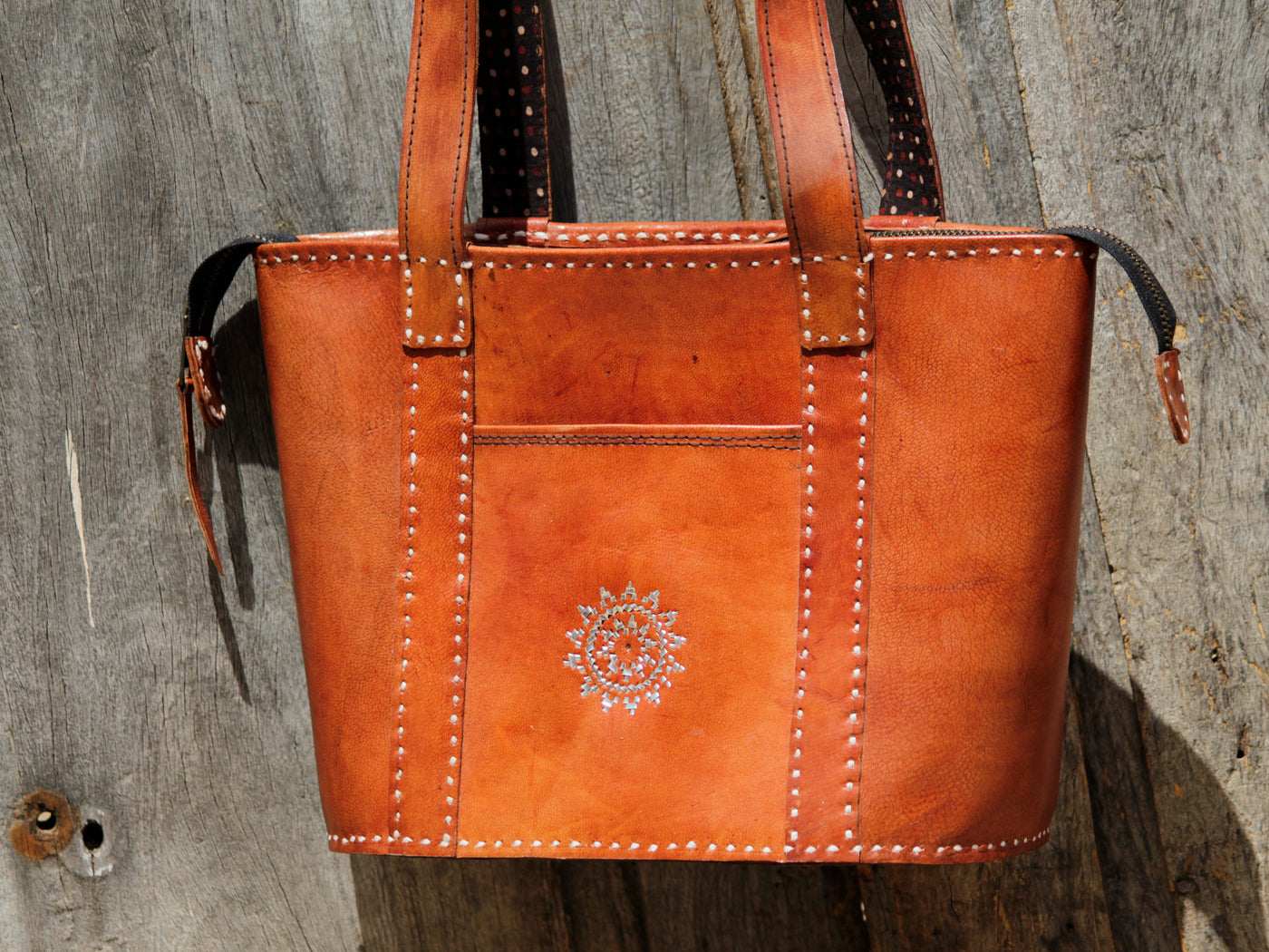 Leather bag adorned with intricate zari work on premium handcrafted leather