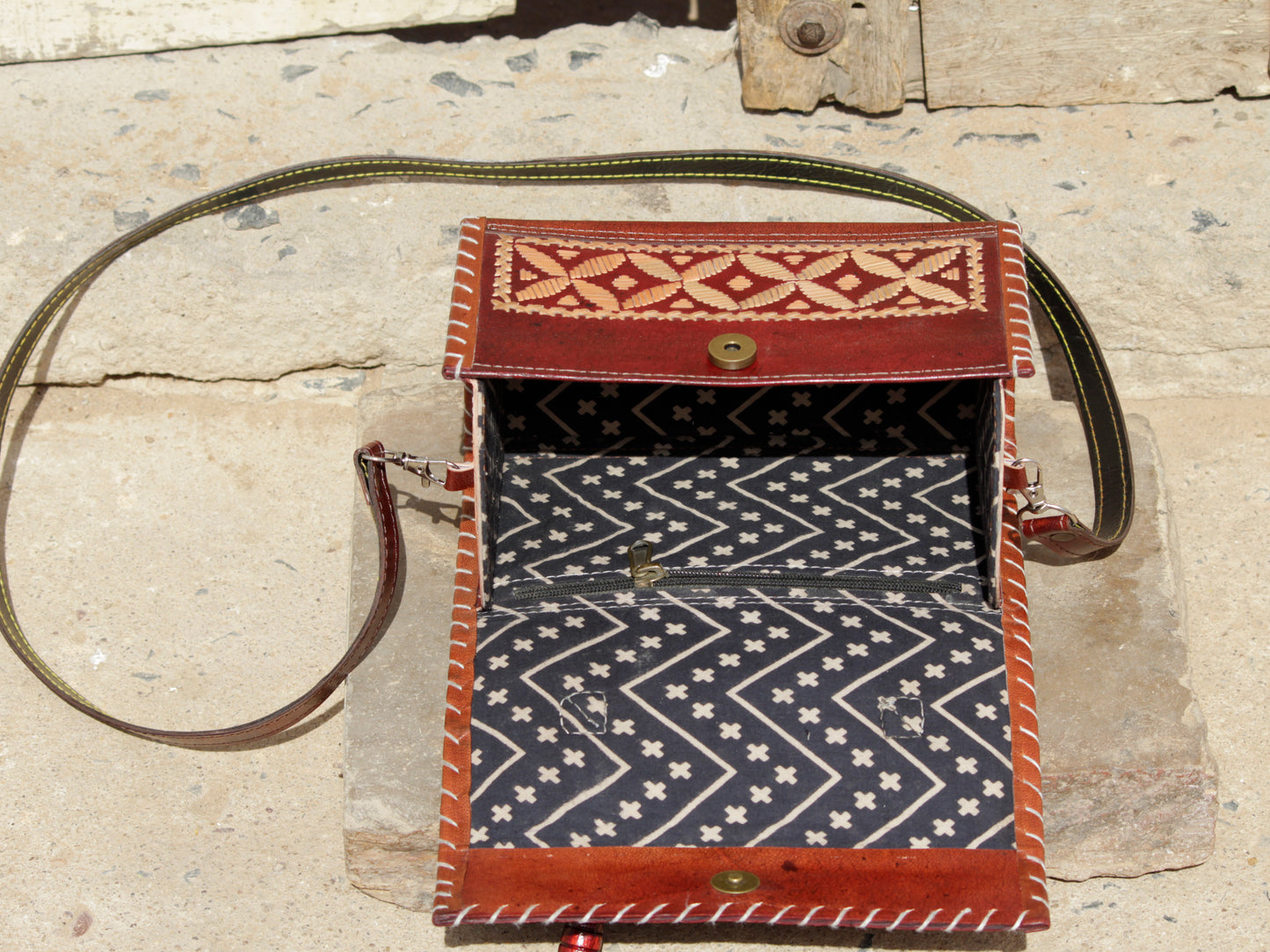 Artisan-made leather hut bag adorned with traditional thread embroidery and fine detailing