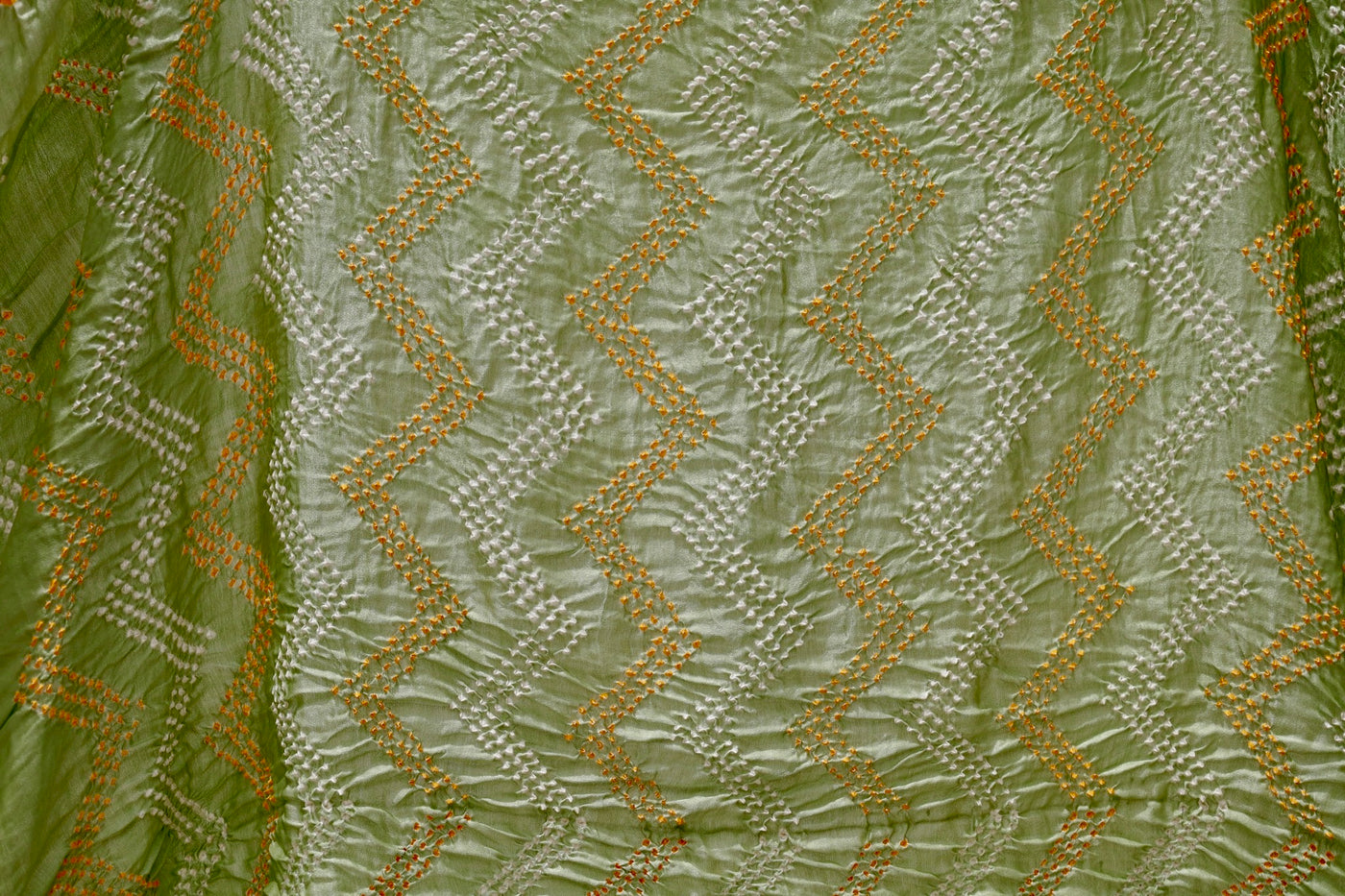 Sage green Rai Bandhani silk saree featuring intricate tie-dye patterns and an elegant zari pallu