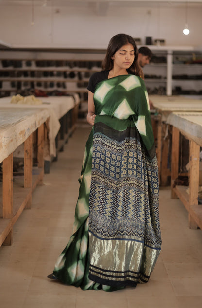 Emerald green clamp dyed Ajrakh modal silk saree featuring intricate patterns and an elegant zari border