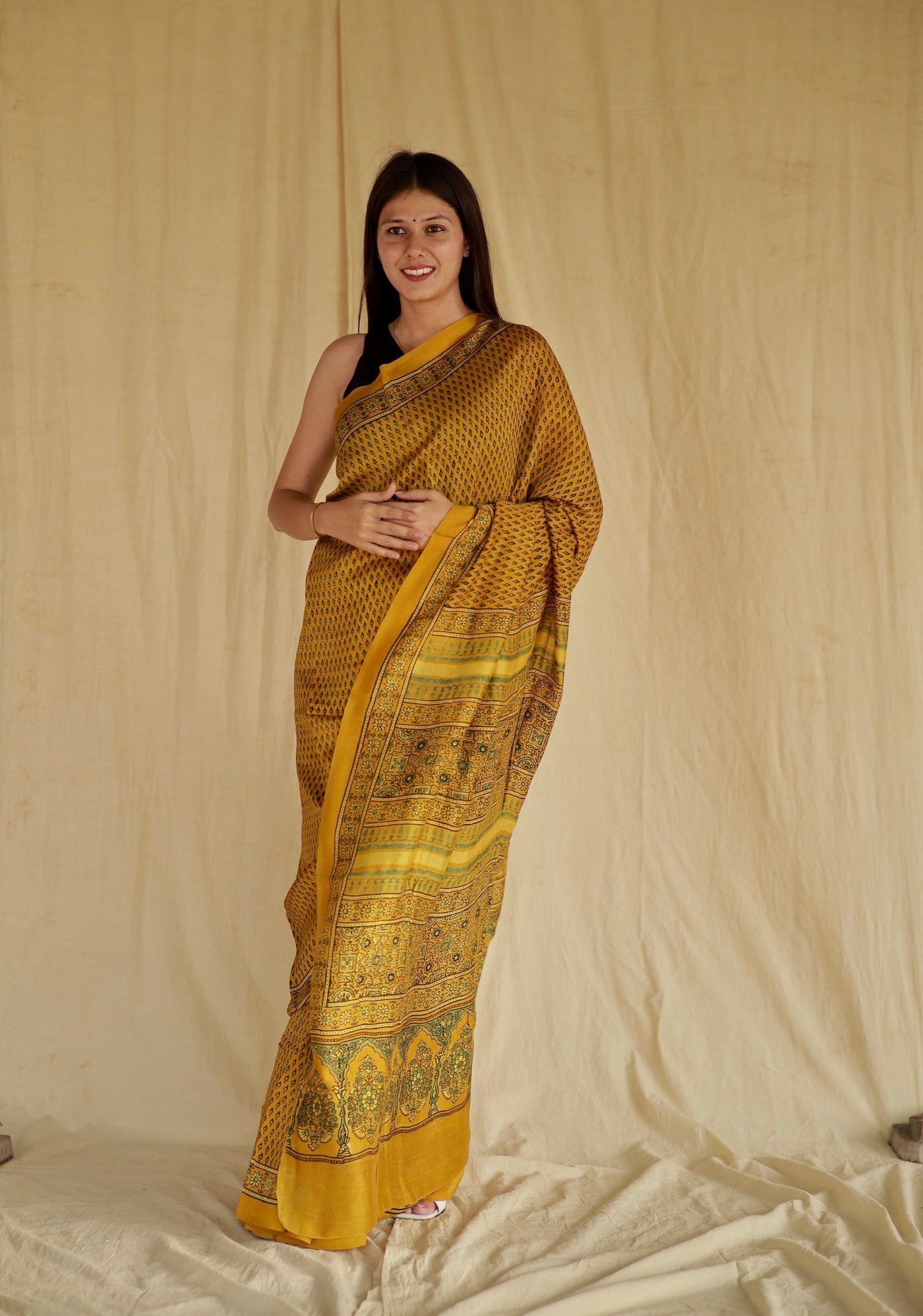 Handcrafted golden mustard Chanderi silk saree adorned with traditional Ajrakh patterns and delicate texture
