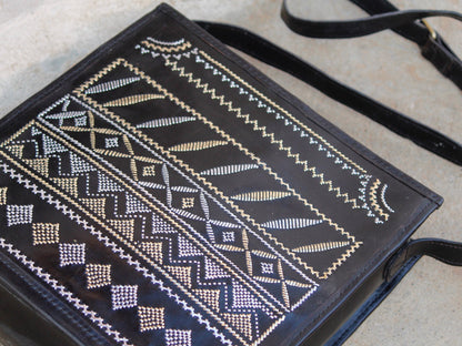 Artisan-made black leather bag featuring traditional metallic zari embellishments