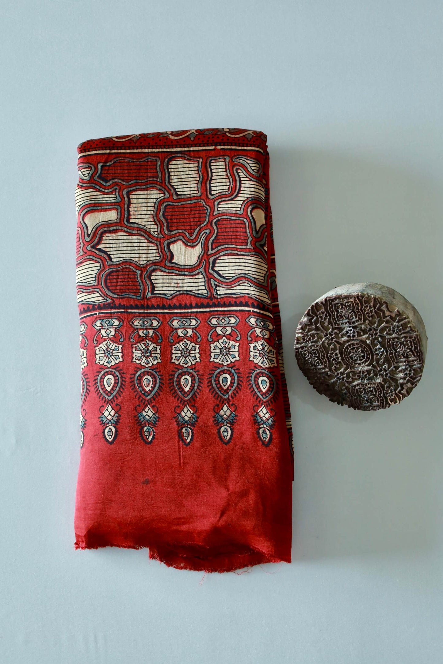 Traditional crimson red Ajrakh modal silk saree with rich artisanal prints and a soft flowing texture