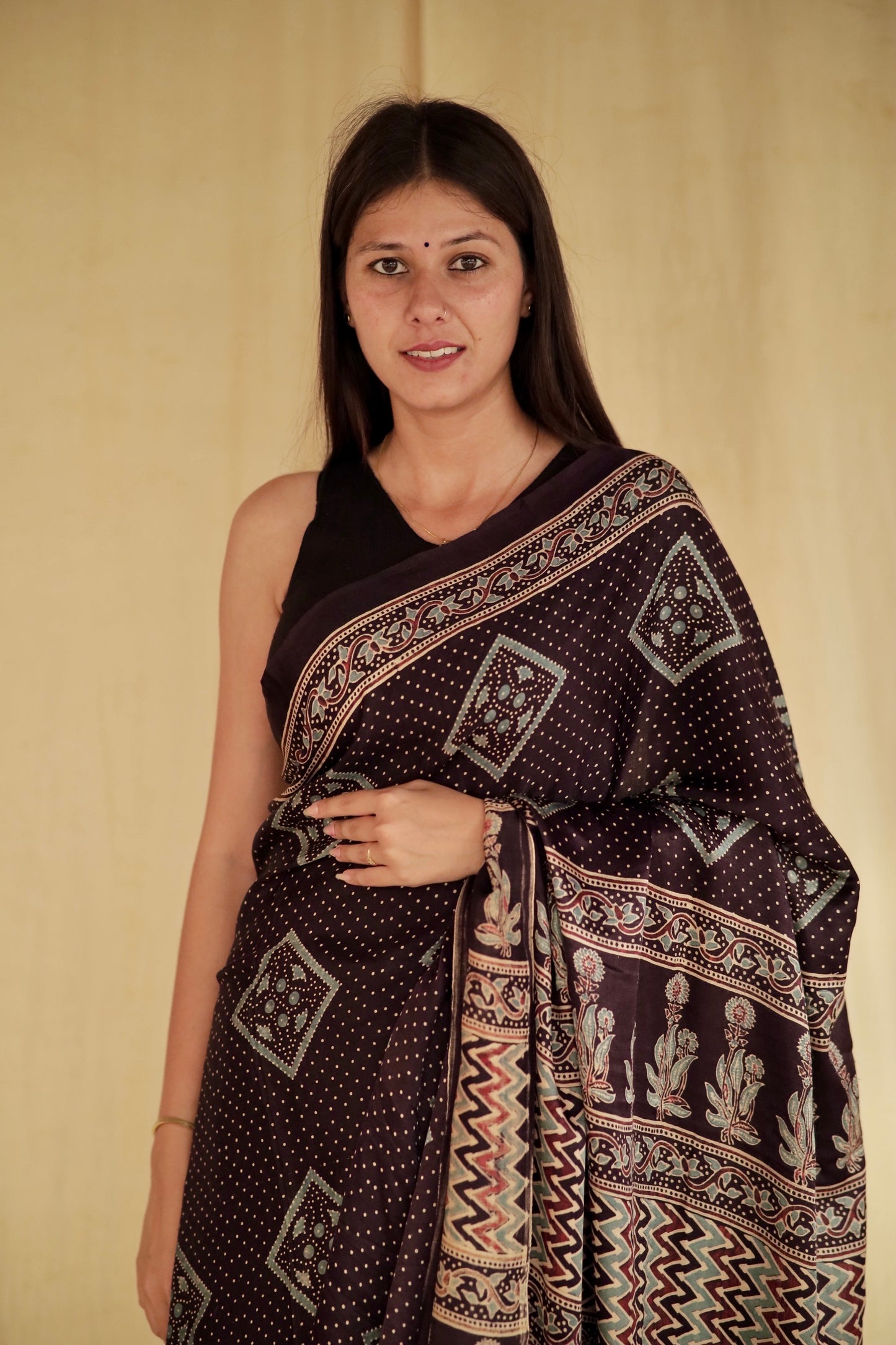 Traditional deep black Ajrakh modal silk saree with rich artisanal prints and a soft flowing texture