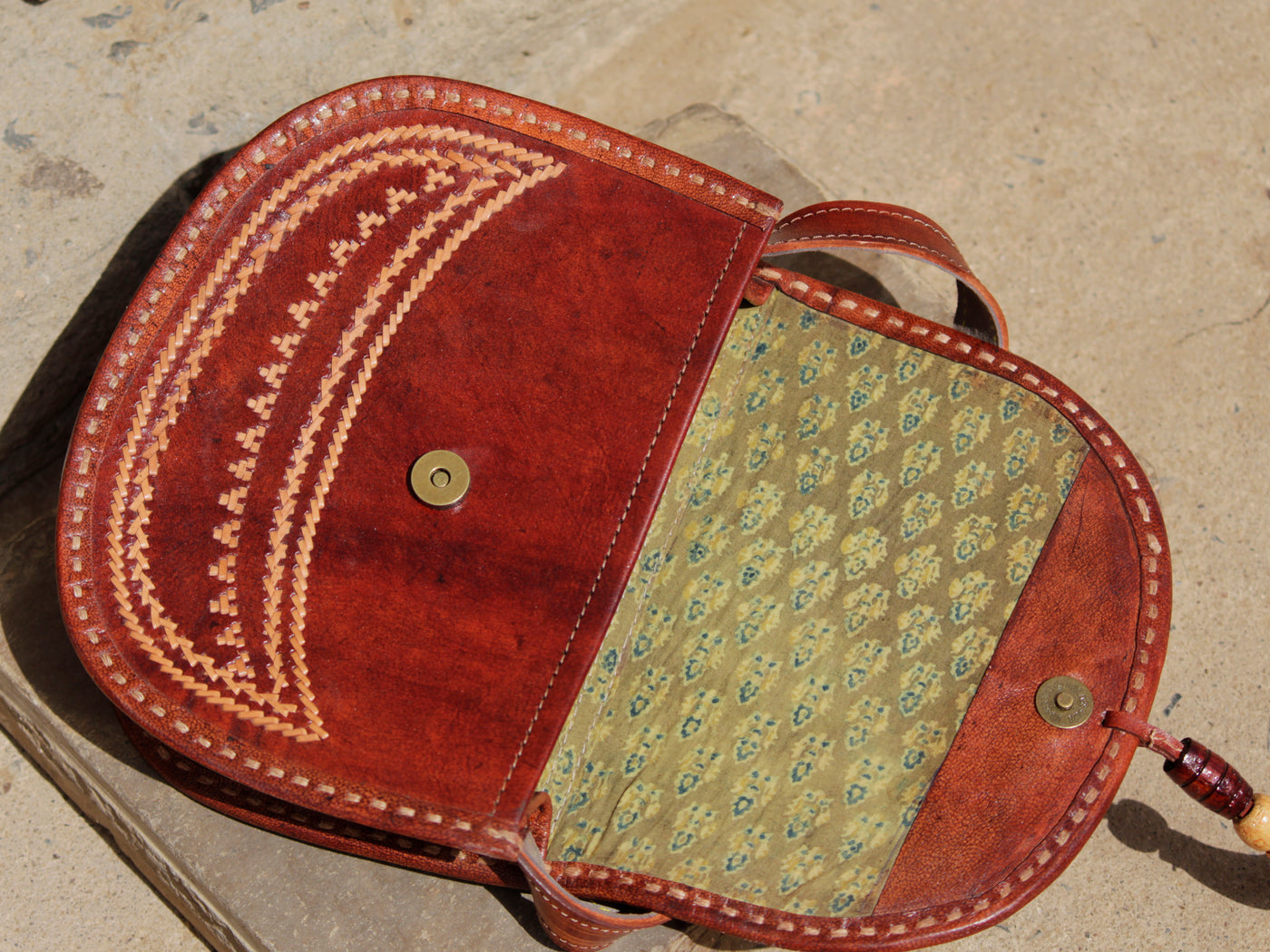 Artisan-crafted leather bag featuring traditional thread embroidery and fine detailing
